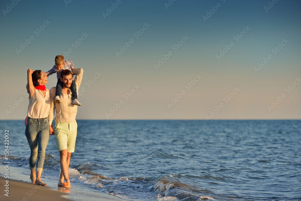 happy young family have fun on beach run and jump at sunset happy young family have fun on beach run and jump at sunset