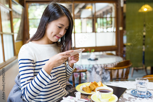 Woman taking photo on her breakfast in cafe