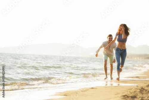happy couple waling on the beach and having fun