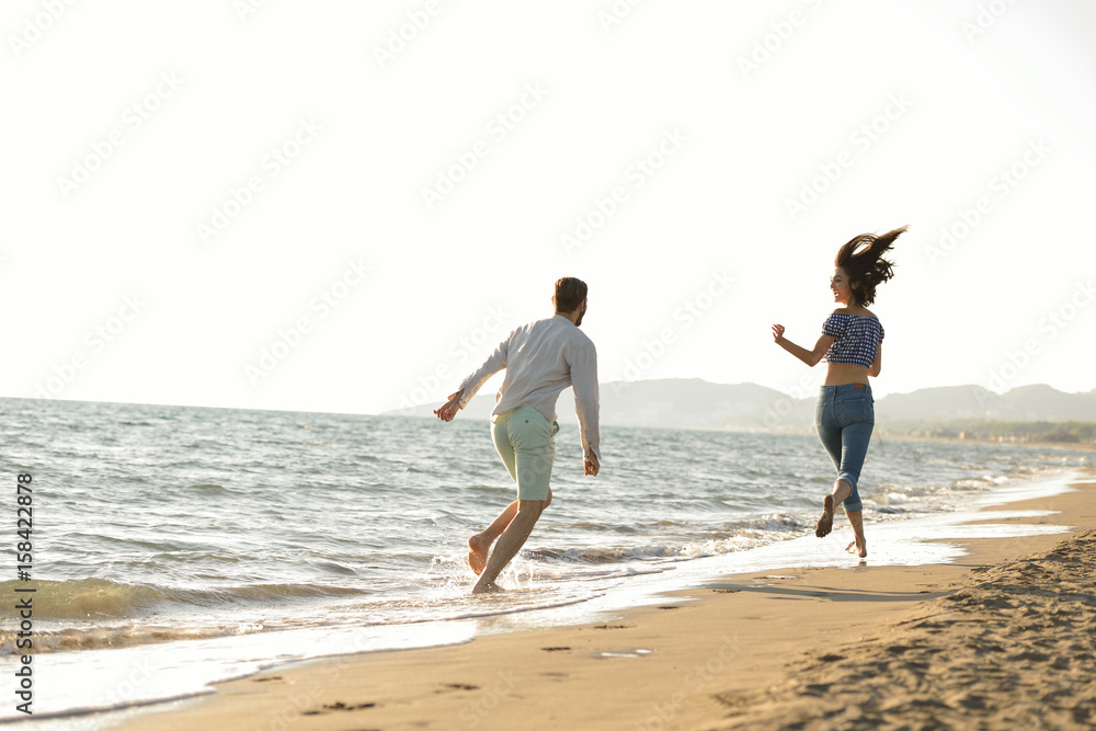 happy couple waling on the beach and having fun happy couple waling on the beach and having fun