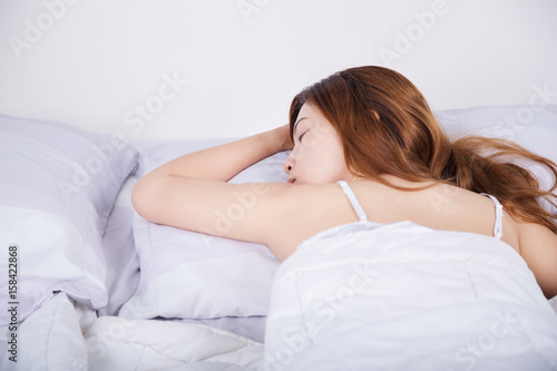 Woman sleeping on bed in bedroom