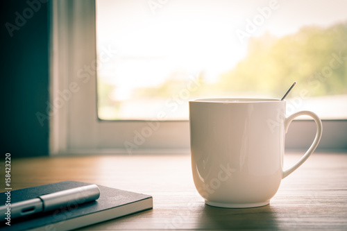 A cup of coffee is placed at the window.