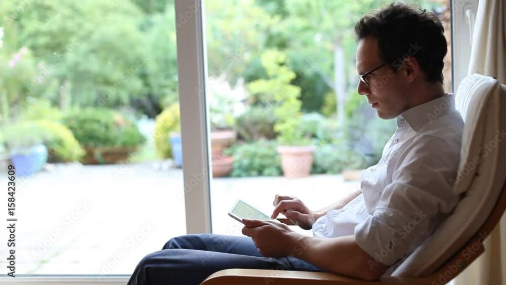 businessman typing email message on tablet computer at home businessman typing email message on tablet computer at home
