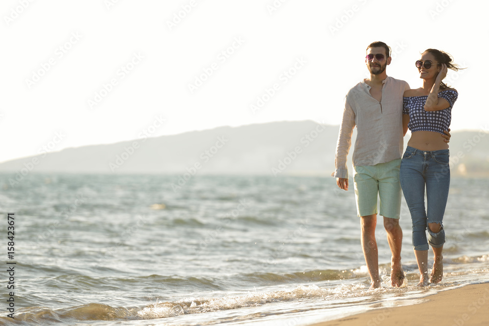 happy couple waling on the beach and having fun
