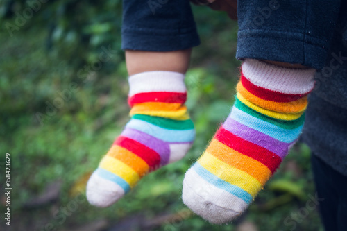 Wearing Colorful Socks / Kid Feet Wearing Colorful Socks In The Winter Season.