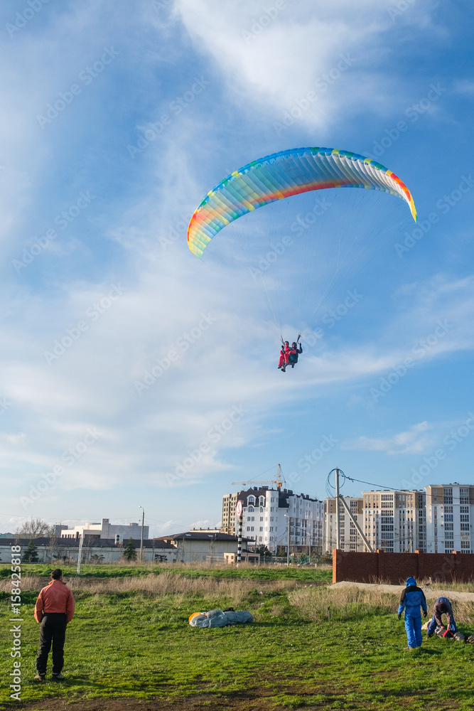Obraz premium Landing a tandem paraglider on paradrome on a Sunny day