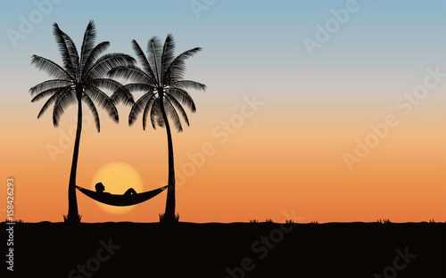 Silhouette palm tree with hammock on beach under sunset sky background