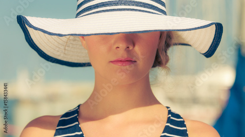 Closeup of fashion woman in striped summer hat.