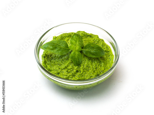 Green pesto sauce and basil, isolated on white. 