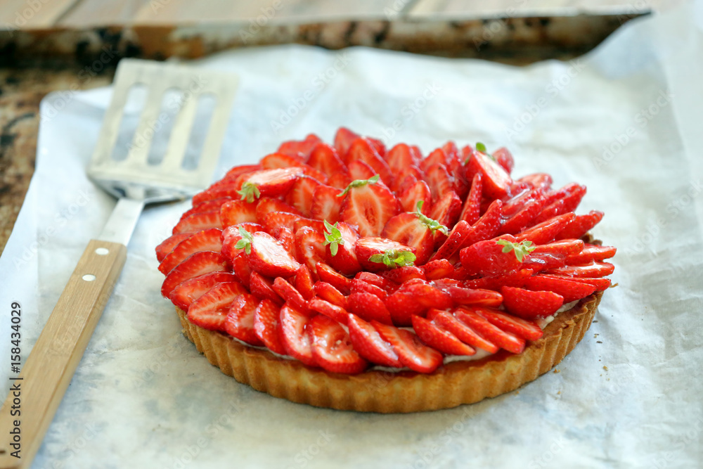 Tart with fresh strawberries on a wooden background