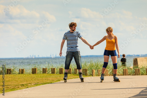 Young couple on roller skates riding outdoors