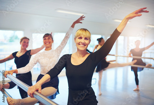 Group of mature ballet dancers looking at camera in class