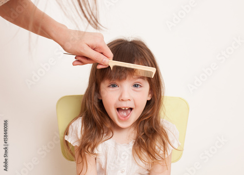 Mother cuts daughter's hair at home