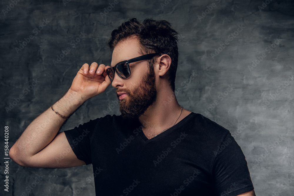Fototapeta premium Stylish bearded male in sunglasses over grey background.