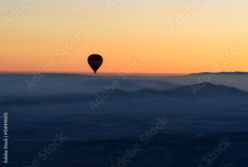 Hot air balloon flying over valley at sunrise. Cappadocia. Turkey © Elena Odareeva