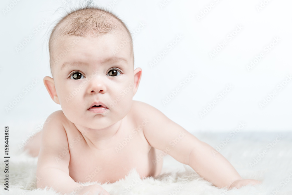 Cute baby lies on a white fluffy background Cute baby lies on a white fluffy background