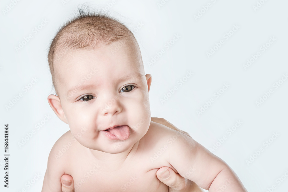 Cute baby shows tongue on a white background Cute baby shows tongue on a white background