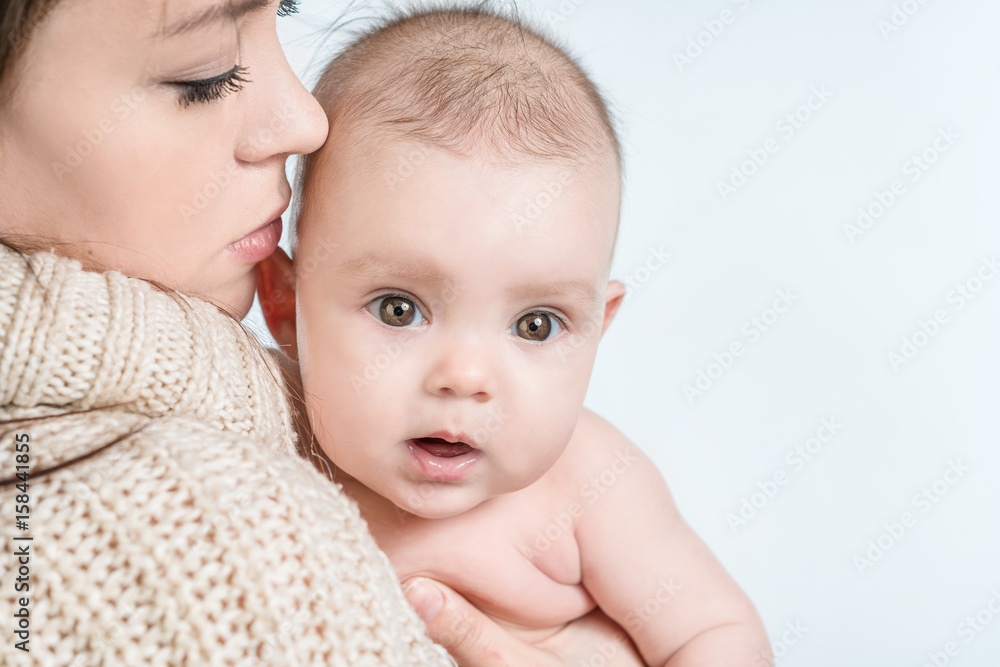 Young woman holding a baby on a white background Young woman holding a baby on a white background