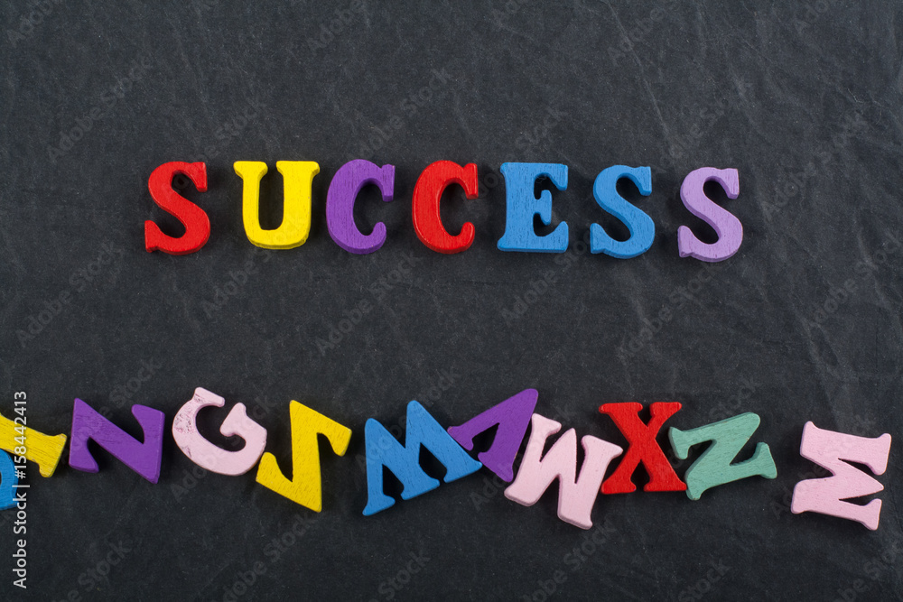 SUCCESS word on black board background composed from colorful abc alphabet block wooden letters, copy space for ad text. Learning english concept. SUCCESS word on black board background composed from colorful abc alphabet block wooden letters, copy space for ad text. Learning english concept.