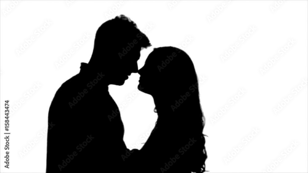 Loving couple look at each other and begin to kiss. Silhouette. White background. Slow motion Loving couple look at each other and begin to kiss. Silhouette. White background. Slow motion