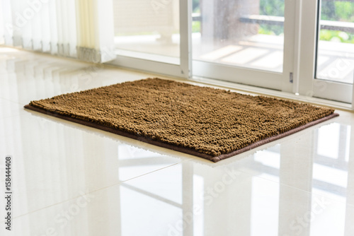 Brown cleaning door mat on the floor.