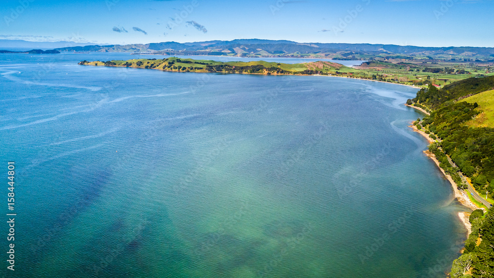 Obraz premium Aerial view on beautiful harbour with sunny beach and surrounding hillside, New Zealand