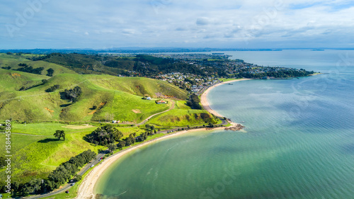 Aerial view on sunny beach with residential suburb on the background. Auckland, New Zealand.