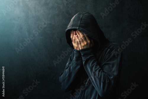 Φωτογραφία Desperate man in hooded jacket is crying