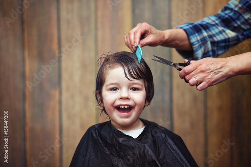 A little boy is trimmed in the hairdresser's