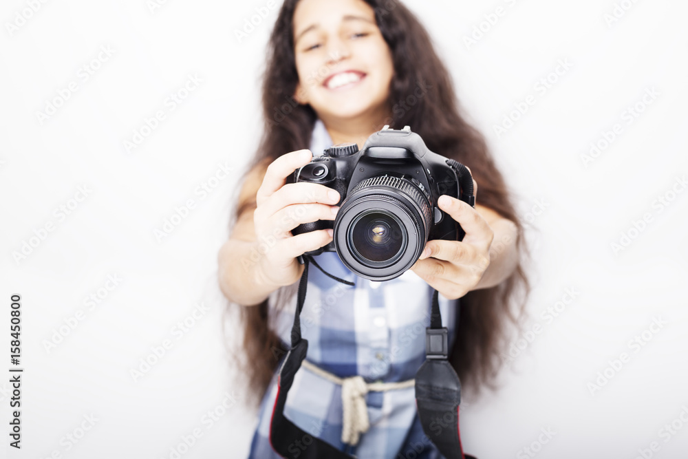 Cute brunette little girl holding an photo camera, isolated on white background Cute brunette little girl holding an photo camera, isolated on white background