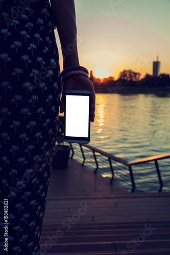 Girl using cellphone in city / urban surroundings - near river.