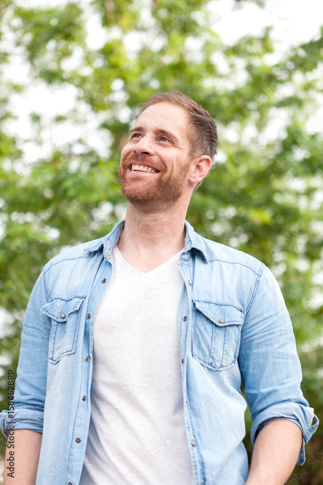 Casual guy with a denim shirt in a park Casual guy with a denim shirt in a park