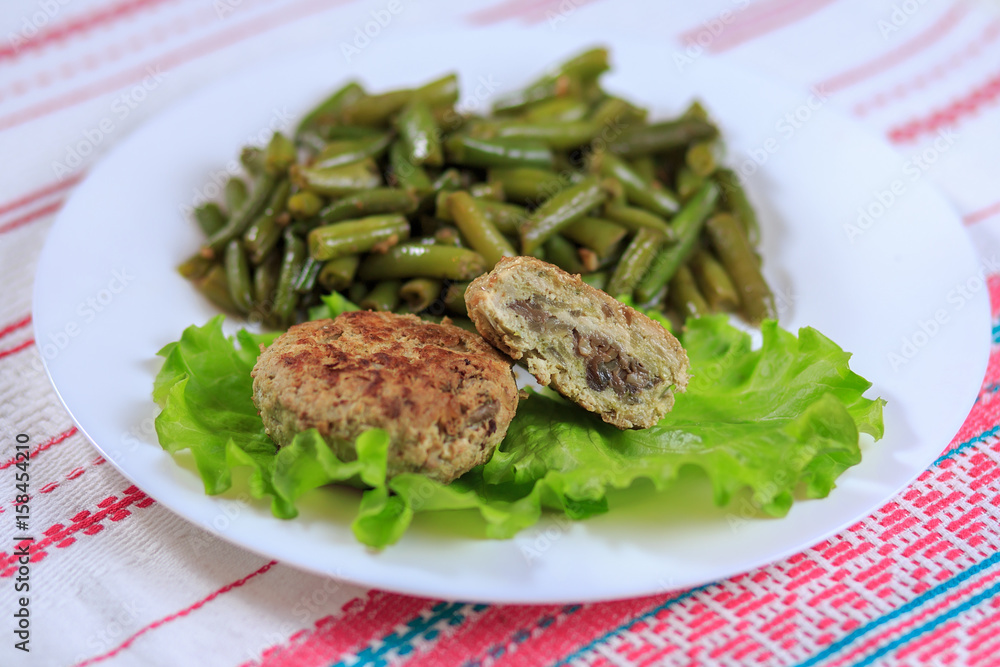 Cutlets with a stuffing with a garnish on a white plate on a light background Cutlets with a stuffing with a garnish on a white plate on a light background