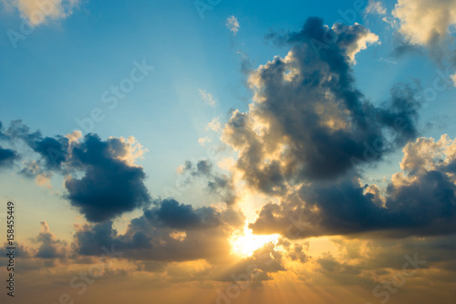 Sunset with sun rays, sky with clouds and sun.