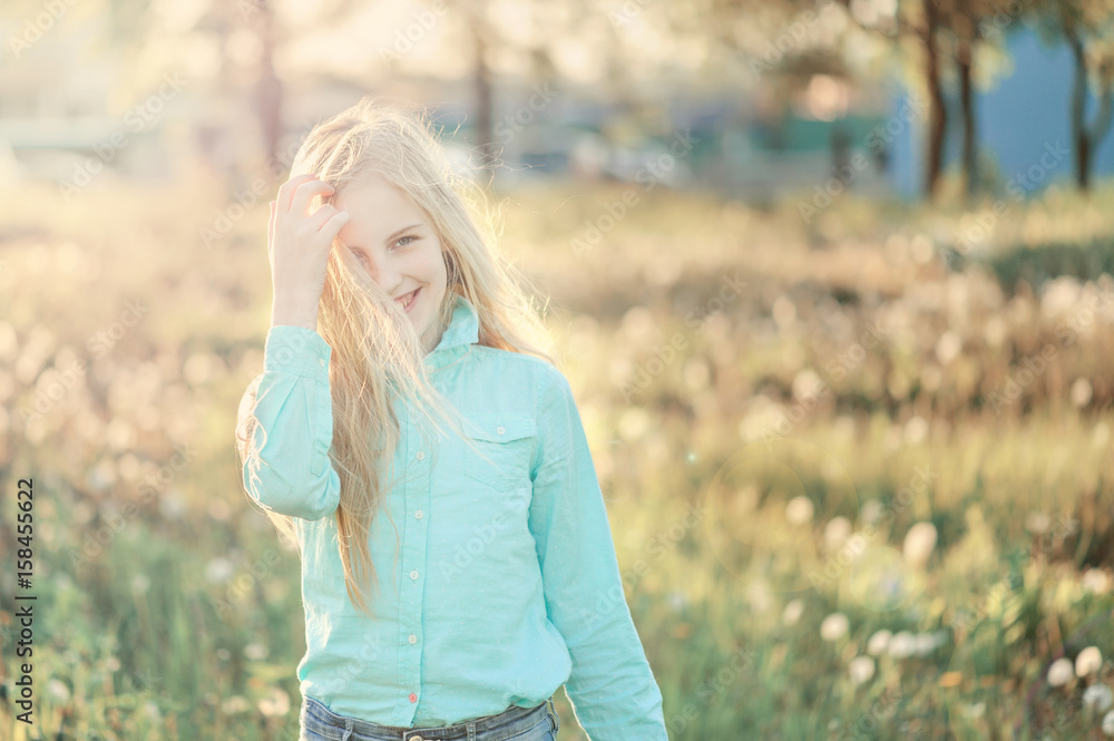 Beautiful smiling teenage girl in blouse, against green of summer park. Sunlight, happiness, fun, hair, joy. Beautiful smiling teenage girl in blouse, against green of summer park. Sunlight, happiness, fun, hair, joy.
