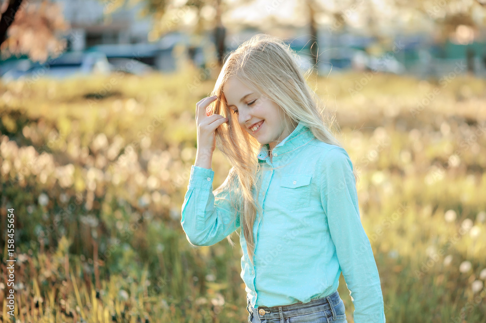 Beautiful smiling teenage girl in blouse, against green of summer park. Sunlight, happiness, fun, hair, joy. Beautiful smiling teenage girl in blouse, against green of summer park. Sunlight, happiness, fun, hair, joy.