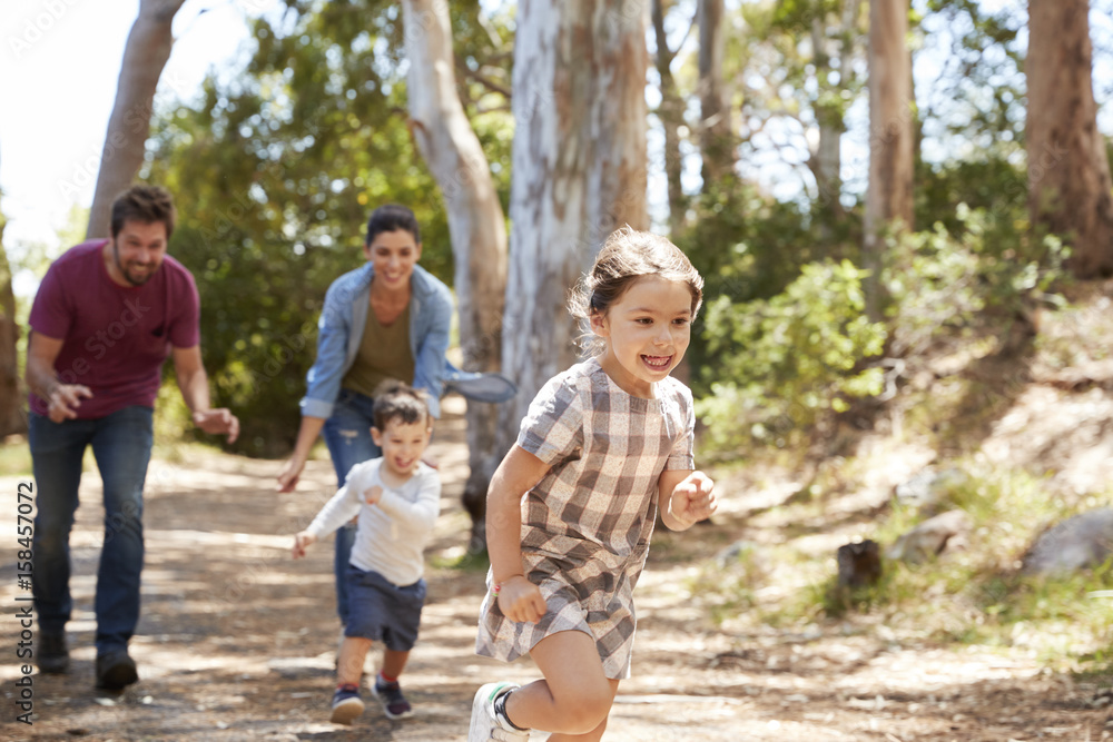 Family Running Along Path Through Forest Together Family Running Along Path Through Forest Together