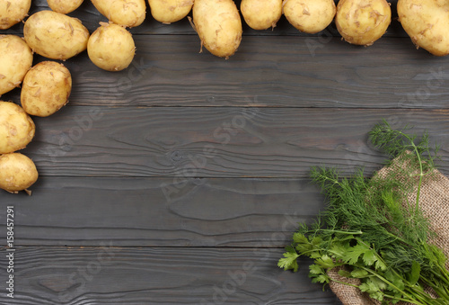 Raw potato on wooden background. Top view with copy space.