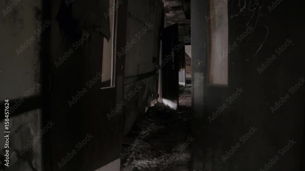 FPV, CLOSE UP: Walking along dark narrow hallway in abandoned decaying psychiatric hospital. Moving past the weathered wooden doors and broken crumbling walls in sinister sanatorium looking for escape FPV, CLOSE UP: Walking along dark narrow hallway in abandoned decaying psychiatric hospital. Moving past the weathered wooden doors and broken crumbling walls in sinister sanatorium looking for escape