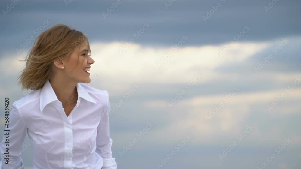 Blonde laughing in the background of clouds Blonde laughing in the background of clouds