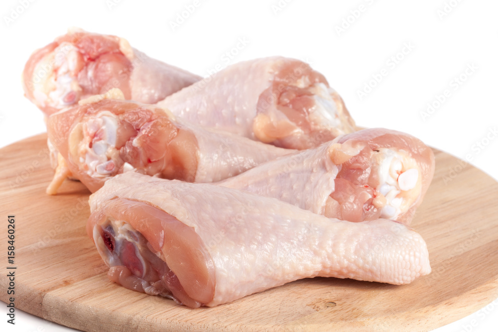 raw chicken drumsticks on a wooden cutting boardn white background raw chicken drumsticks on a wooden cutting boardn white background