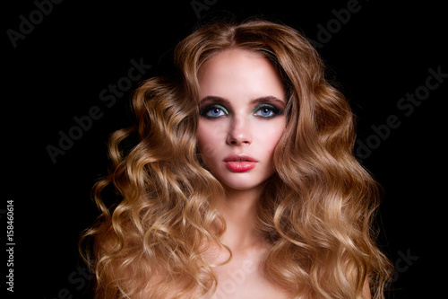 Beauty Fashion Model Woman   portrait   hairstyle with creative hair-dress  curls waves. Concept Girl face with perfect skin in dark Background