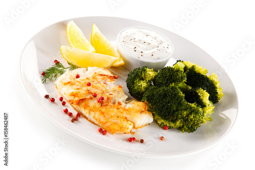 Fried fish fillet with broccoli on white background