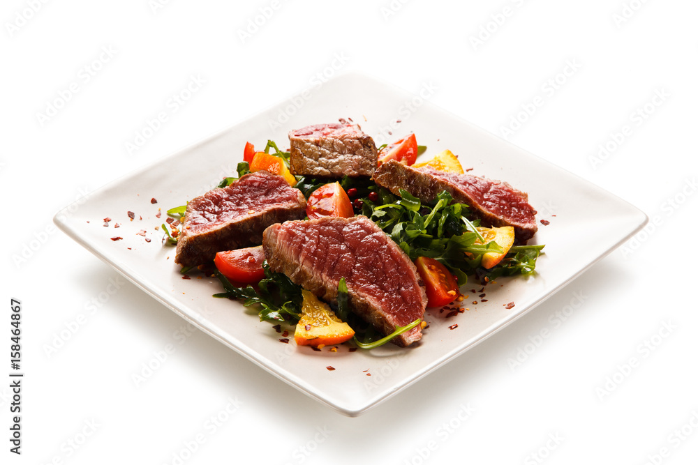 Fillet mignon - grilled beefsteaks with vegetables on white background