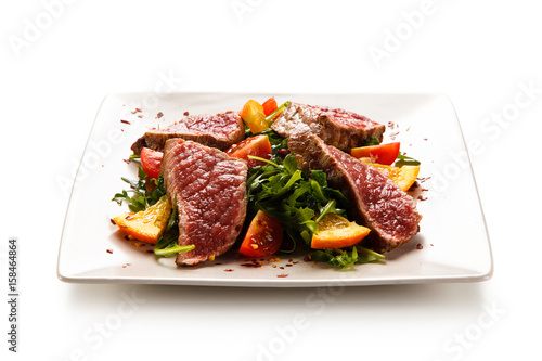 Fillet mignon - grilled beefsteaks with vegetables on white background