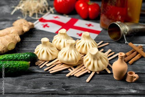 Khinkali on a wooden table with vegetables