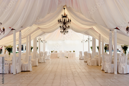 Marquee for the celebration of the wedding. Beautiful white interior with white draperies