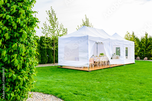 Party tent - white garden party or wedding entertainment tent in modern garden