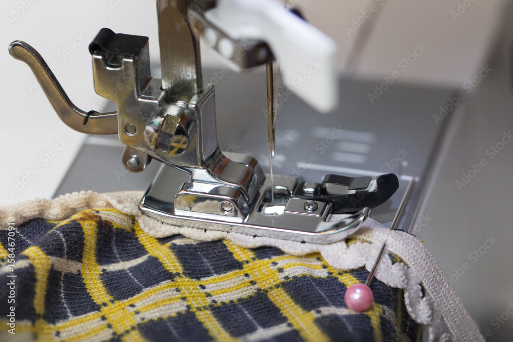 Work on a sewing machine with an overlock foot, joining a rubber band with a zigzag stitch
