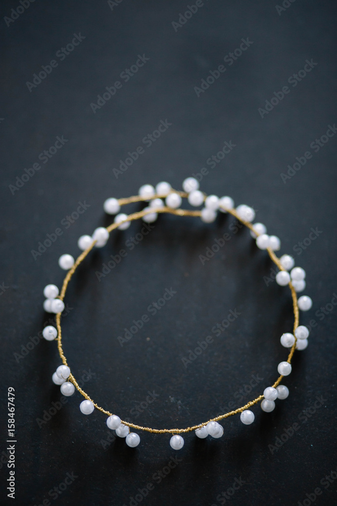 wedding decoration for hair a wreath of white beads and beaded close-up on black light grey wood background copyspace wedding decoration for hair a wreath of white beads and beaded close-up on black light grey wood background copyspace